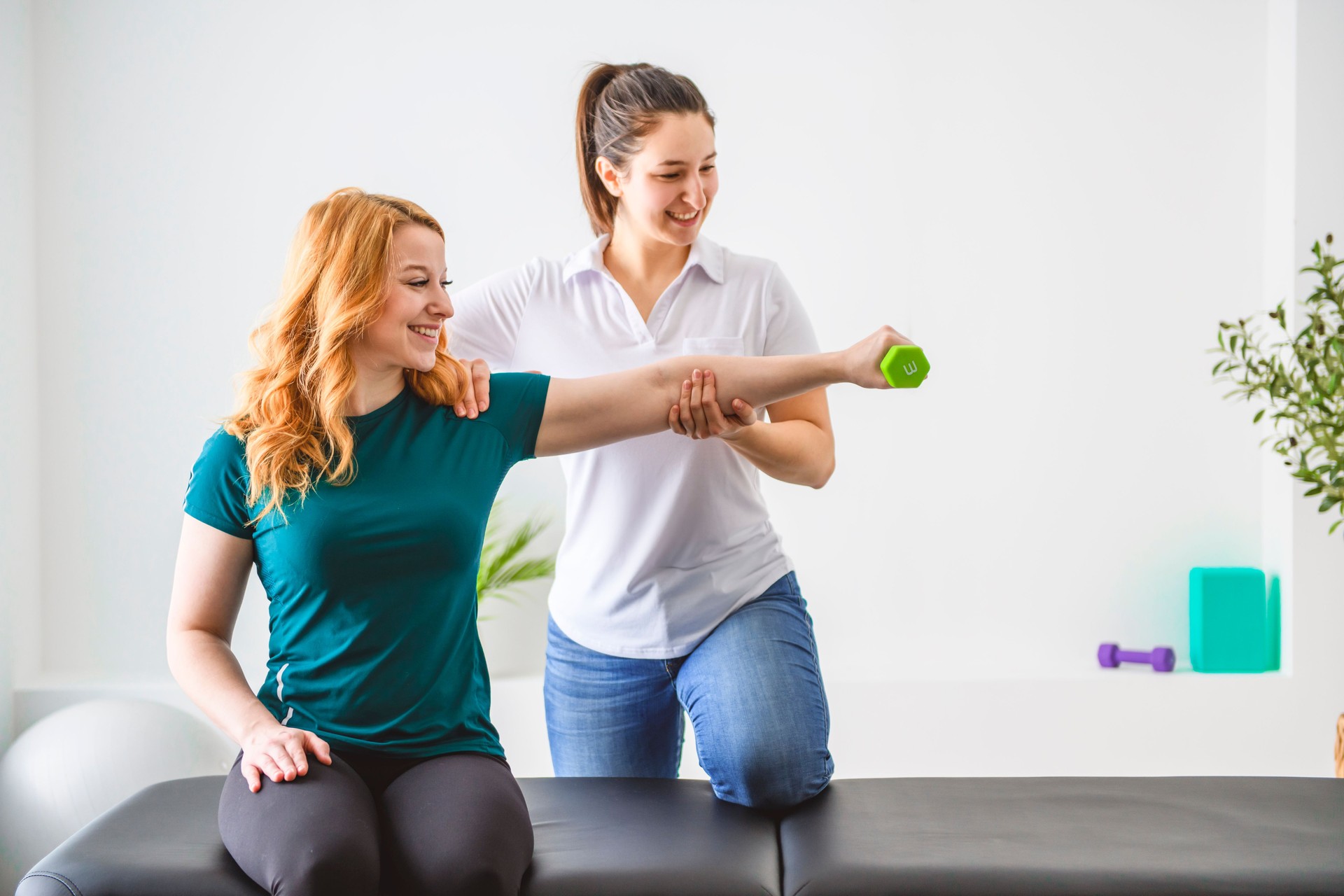 Modern rehabilitation physiotherapy at work with client holding dumbbell