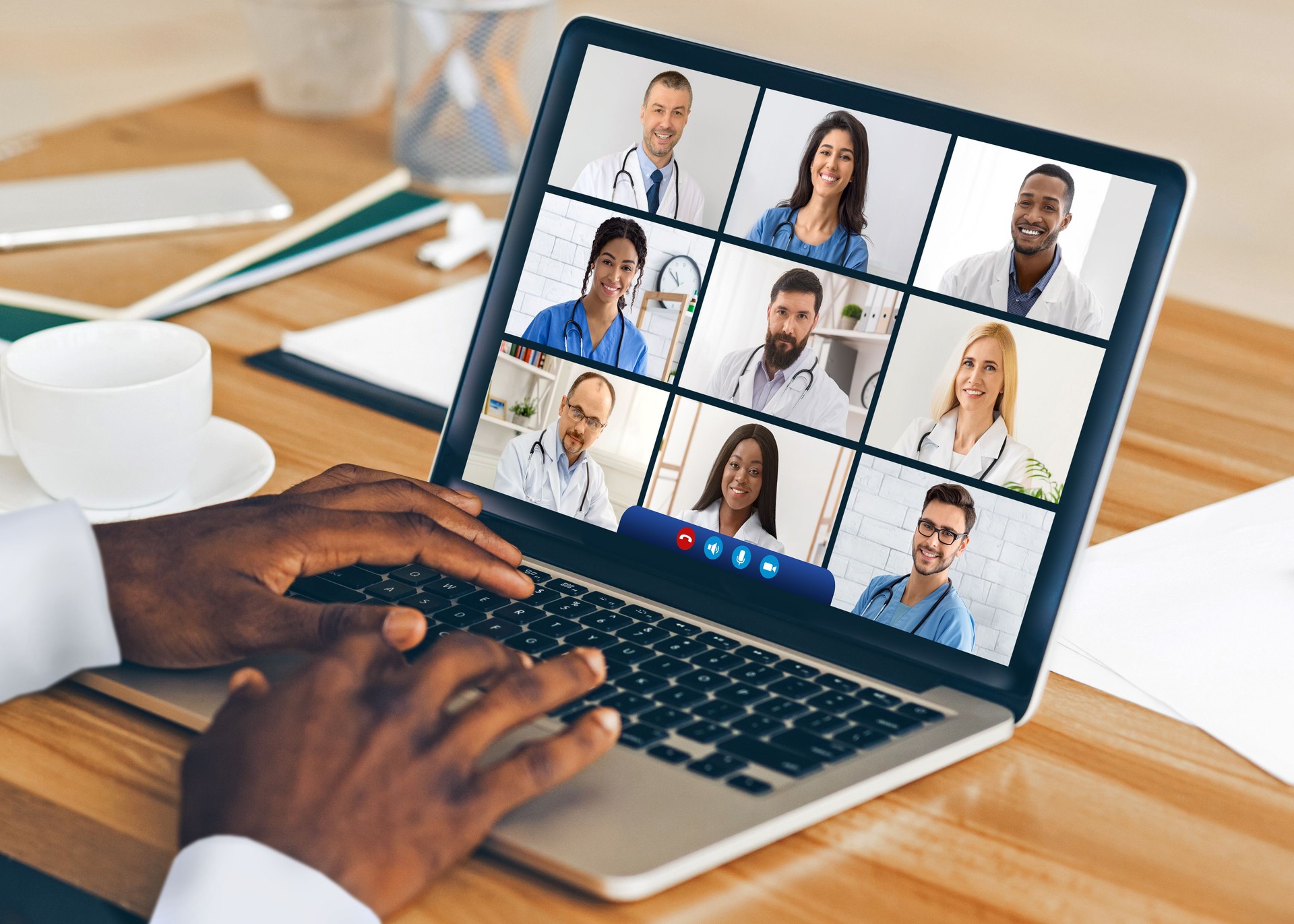 Black Doctor At Laptop Having Video Conference With Colleagues Indoor